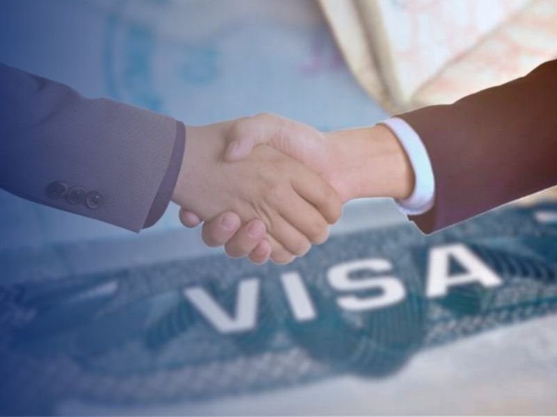 Immigration attorney and franchise client shaking hands over a visa application
